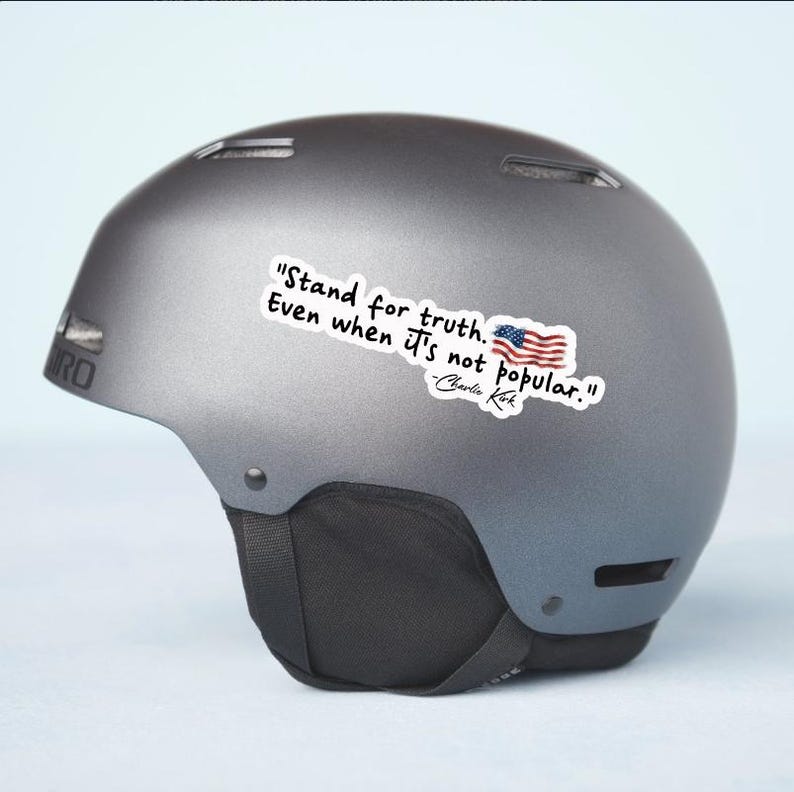 May include: A gray Giro ski helmet with a sticker that reads "Stand for truth. Even when it's not popular." and an American flag graphic. The quote is attributed to Charlie Kirk.
