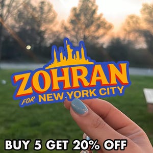 Zohran Mamdani Sticker featuring the name "ZOHRAN" in large orange and red letters, with a yellow silhouette of the New York City skyline above it and the text "FOR NEW YORK CITY" below. This bold, blue-bordered design serves as a compelling 2025 Campaign Decal. Ideal as a Progressive Bumper Sticker or a mock Zohran Car Magnet. A perfect NYC Election Gift or accessory for supporters who want to Vote Zohran. High-quality, durable vinyl sticker for laptops and water bottles.