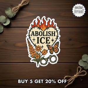 May include: A waterproof sticker with a heart-shaped design featuring the words "ABOLISH ICE" in black. The heart is surrounded by barbed wire and flames, with orange flowers, a butterfly, and handcuffs. The sticker is on a wooden surface.
