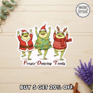 May include: A sticker featuring three cartoon frogs dressed for the holidays. One frog is in a Santa suit, another is adorned with Christmas lights, and the third wears a sweater and antlers. The text "Frosty Dancing Toads" is below the frogs.