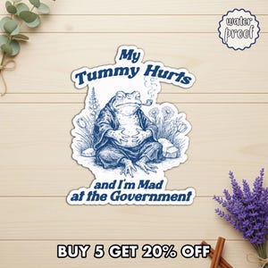 May include: A blue and white sticker featuring a cartoon toad smoking a pipe, with the text "My Tummy Hurts and I'm Mad at the Government." The sticker is labeled "water proof."