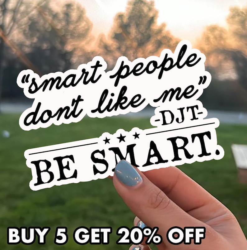May include: A white sticker with black text that reads "smart people don't like me" and "BE SMART." The sticker is held by a hand with a blue painted nail. The text "BUY 5 GET 20% OFF" is at the bottom.