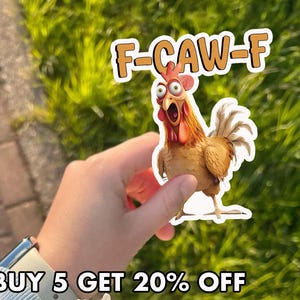 May include: A sticker featuring a cartoon rooster with wide eyes and an open beak, with the text "F-CAW-F" above it. The sticker is held against a background of green foliage.