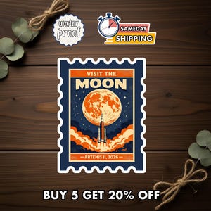 May include: A sticker with a vintage travel poster design. The sticker features a large orange moon, a rocket launching, and the text "VISIT THE MOON". The sticker also includes the text "ARTEMIS II, 2026". The sticker is bordered in blue.