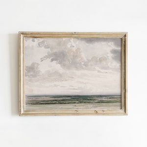 Könnte beinhalten: Gerahmtes Landschaftsgemälde mit bewölktem Himmel und ferner Küstenlinie. Das Kunstwerk ist in gedämpften Grautönen, Grün und Beige gehalten, mit einem verwitterten, goldfarbenen Rahmen. Das Gemälde vermittelt Ruhe und natürliche Schönheit.