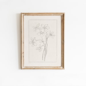 Könnte beinhalten: Ein gerahmtes Schwarzweiß-Linienbild eines Blumenstraußes. Die Blumen sind stilisiert und haben ein schlichtes, elegantes Design.