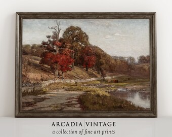 May include: A vintage painting of a rural landscape with a stream, trees, and a stone wall. The trees are in autumn colors, with red, orange, and yellow leaves. There are cows grazing in a field in the distance. The painting is framed in a dark wood frame.