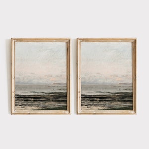May include: Two framed paintings of a seascape with a light blue sky, a pink horizon, and a dark blue ocean with white waves. The paintings are in light wood frames.