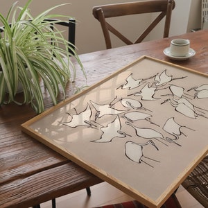 This vintage Japanese art print features a flock of egret birds rendered in bold, abstract brushstrokes, against an understated tan background.  A captivating addition to both traditional and modern interiors. Instantly download, print, and frame!