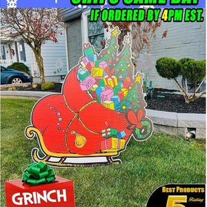 May include: A red Grinch sleigh filled with colourful presents and a Christmas tree. The sleigh is on a green lawn in front of a house. The text "GRINCH SLED" is on a red box in the foreground. The text "HANDCRAFTED YARD SIGNS" is on the bottom of the image.