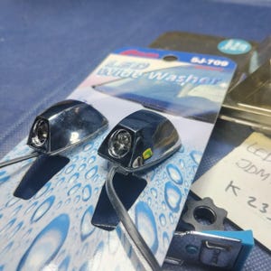 May include: Two chrome LED Wide Washer car accessories are displayed on a blue and white patterned background. The packaging includes the text "LED Wide Washer" and the product code "SJ-709". Additional components and handwritten notes are also visible.