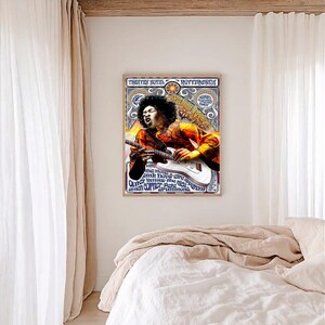 Peut inclure: A framed poster with a vintage design, featuring a musician playing a white electric guitar. The poster includes text such as "Theater Royal Rotterdam" and other names. The musician is wearing a jacket with orange and yellow tones.
