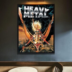 May include: A framed "Heavy Metal" poster. The artwork shows a woman riding a winged creature, holding a sword. The poster is in a black frame, mounted on a dark grey wall. The title "Heavy Metal" is in large, silver letters.