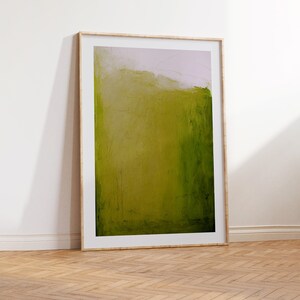 May include: A framed abstract painting with a green and white color scheme. The painting is in a wooden frame and is hanging on a white wall.