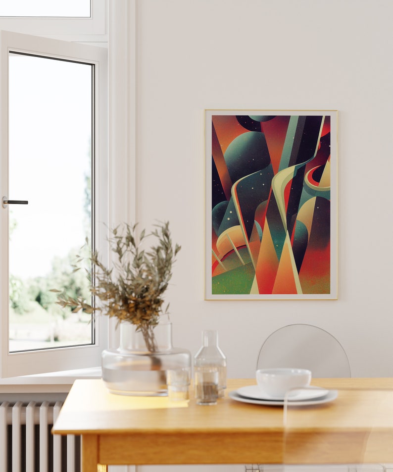 May include: A framed abstract art print with geometric shapes in shades of orange, red, yellow, green, and blue. The print is set against a white wall above a wooden table with a vase of greenery, a glass bottle, and a white bowl.
