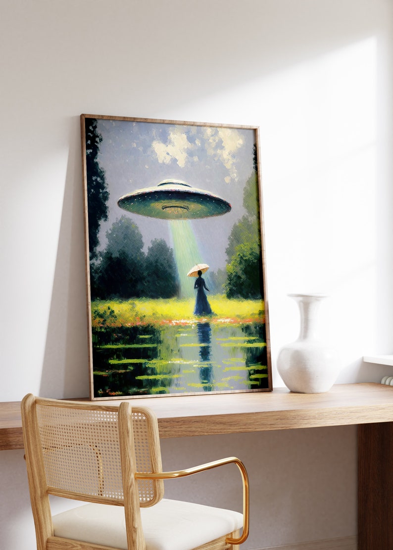 Op de afbeelding: Een ingelijst schilderij van een vrouw in een jurk en hoed die op een veld staat, met een vliegende schotel die boven haar zweeft. De schotel zendt een lichtstraal uit. Het schilderij is geplaatst tegen een witte muur.
