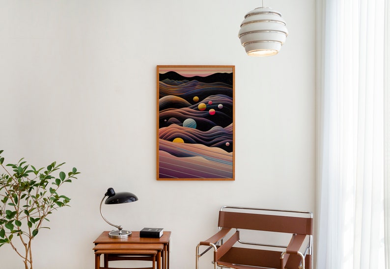 May include: A framed abstract print depicting a dark blue and purple landscape with colourful circles scattered throughout. The print is hanging on a white wall in a modern living room.