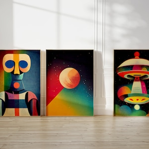 Puede incluir: Tres impresiones de arte abstracto enmarcadas con un tema espacial. La primera impresi&oacute;n presenta un robot geom&eacute;trico colorido con ojos azules. La segunda impresi&oacute;n presenta un gran planeta naranja en un cielo azul oscuro con estrellas. La tercera impresi&oacute;n presenta un platillo volante colorido con una luz amarilla y verde.