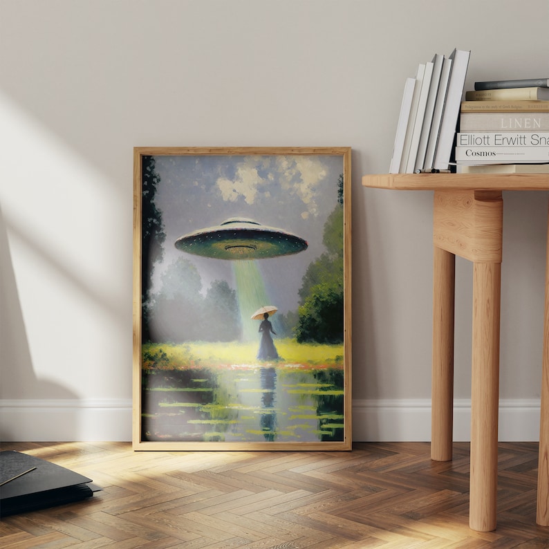 Op de afbeelding: Een ingelijst schilderij van een vrouw die over een veld loopt met een UFO die boven haar zweeft. De UFO zendt een lichtstraal uit die op de vrouw schijnt. Het schilderij is geschilderd tegen een blauwe lucht met witte wolken.