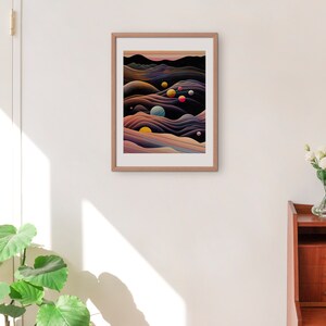 May include: A framed abstract art print with a dark background and colourful, swirling shapes. The print features a series of overlapping, wavy lines in shades of purple, blue, and yellow. There are several small, colourful circles scattered throughout the print.