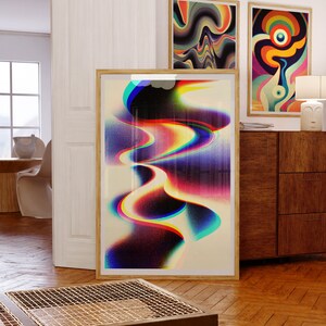 May include: Three framed abstract art prints with colourful, swirling patterns. The prints are hanging on a white wall above a wooden dresser.