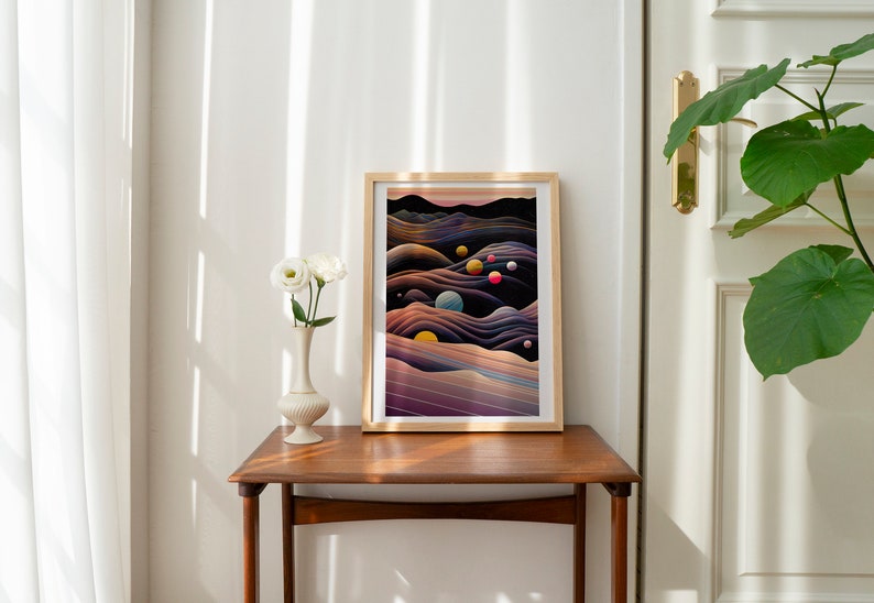 May include: A framed abstract art print with a dark background and colourful orbs. The print features a landscape of swirling, layered lines in shades of purple, blue, and brown. The frame is a light wood colour.