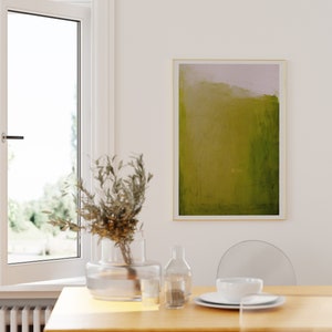 May include: A wooden dining table with a vase of dried branches, a clear glass bottle, and a white ceramic bowl. The table is set with a white plate and a white bowl. A green and yellow abstract painting hangs on the wall behind the table.