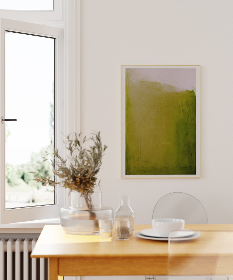 May include: A wooden dining table with a vase of dried branches, a clear glass bottle, and a white ceramic bowl. The table is set with a white plate and a white bowl. A green and yellow abstract painting hangs on the wall behind the table.