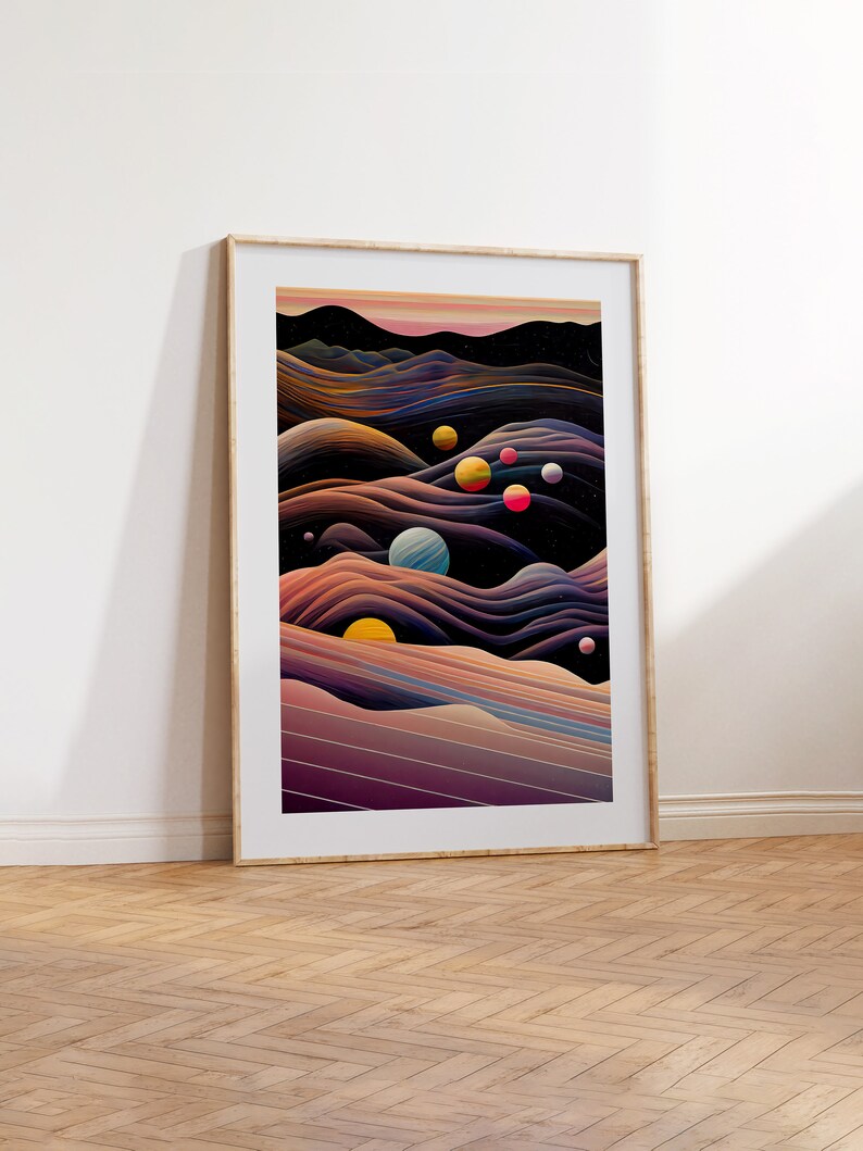 May include: Abstract art print featuring a landscape with colourful planets and a dark blue sky. The print is framed in a light wood frame.
