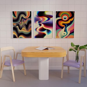 May include: Three abstract art prints with colourful, swirling patterns hang on a white tiled wall above a wooden table with two light purple chairs. A potted plant sits on the table.