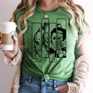 May include: Green t-shirt with a black graphic of four horror movie characters' faces. The characters are Jason Voorhees, Freddy Krueger, Michael Myers, and Leatherface.