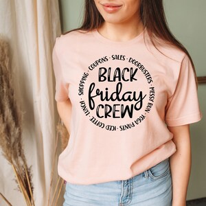 May include: A pink t-shirt with a black circle graphic that says "Black Friday Crew" with a list of activities around the circle.
