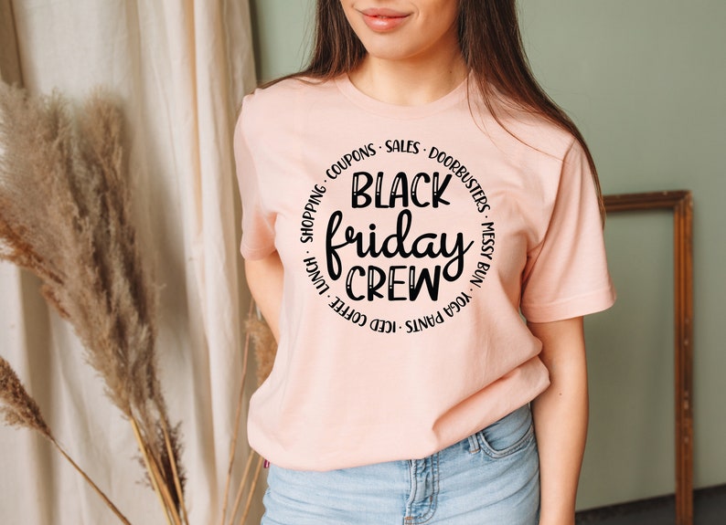 May include: A pink t-shirt with a black circle graphic that says "Black Friday Crew" with a list of activities around the circle.