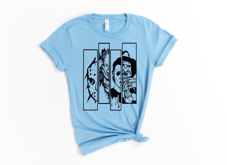 May include: Light blue t-shirt with a black graphic of four horror movie characters in a row. The characters are Jason Voorhees, Freddy Krueger, Michael Myers, and Leatherface.