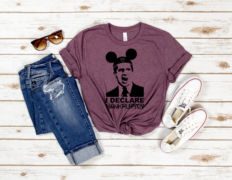 May include: A maroon t-shirt with a black silhouette of a man wearing Mickey Mouse ears and the text "I Declare Bankruptcy".