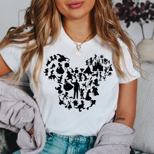 May include: A white t-shirt featuring a black silhouette of Mickey Mouse's head formed from various Disney characters.