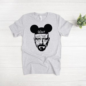 May include: A gray t-shirt with a black and white image of Walter White from the TV show Breaking Bad wearing Mickey Mouse ears with the word "WALT" on the headband.