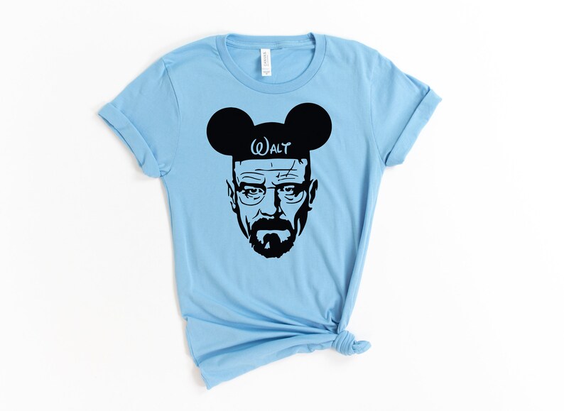May include: Light blue t-shirt with a black silhouette of Walter White from Breaking Bad wearing Mickey Mouse ears with the word "WALT" on the headband.