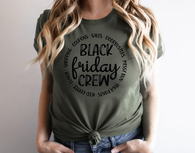 May include: A green t-shirt with a black circle graphic that says "Black Friday Crew" with the words "Yoga Pants, Messy Bun, Doorbusters, Sales, Coupons, Shopping, Iced Coffee, Lunch" surrounding the text.
