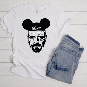 May include: White t-shirt with a black silhouette of Walter White from Breaking Bad wearing Mickey Mouse ears with the text "WALT" on the headband.