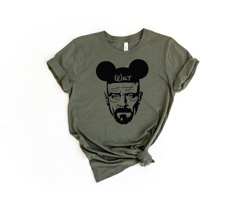 May include: A green t-shirt with a black silhouette of Walter White from the TV show Breaking Bad wearing Mickey Mouse ears with the text "WALT" on the ears.