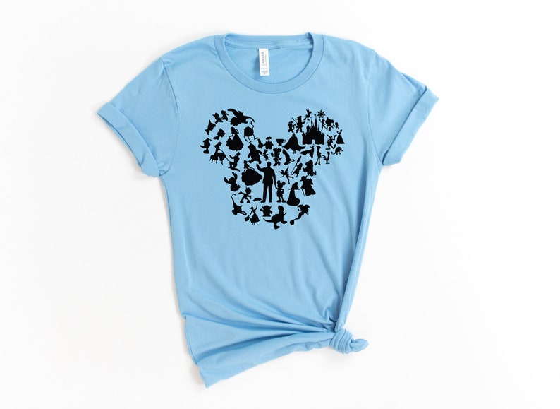 May include: A light blue t-shirt featuring a black silhouette of Mickey Mouse's head formed from various Disney characters.