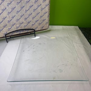 May include: A clear, square crystal platter with etched floral designs. The platter is displayed with its original box, which has a repeating pattern of the words "Princess House". A black metal stand is also visible.