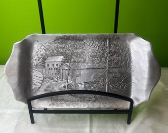 Bandeja vintage de aluminio martillado Wendell August Forge. Aprox. 29,5 x 20 cm. Escena de puente cubierto. Parece provenir de McConell's Mill.