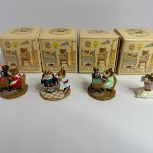 Könnte beinhalten: Set mit vier Miniatur-Mausfiguren, die jeweils eine andere Szene darstellen. Die Mäuse sind in verschiedenen Outfits gekleidet, mit passenden Schachteln, die Illustrationen von Mäusen beim Lesen im Bett zeigen. Die Figuren stehen auf einer weißen Oberfläche.