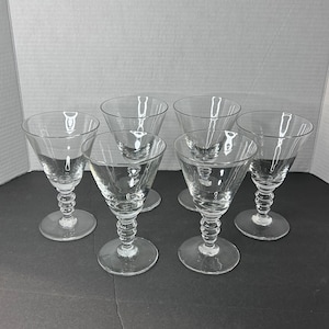 Puede incluir: Juego de seis copas de vino de cristal transparente con tallo y diseño texturizado en el tallo.