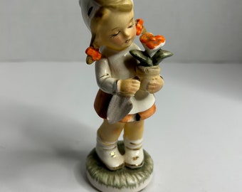 Figura de niña vintage de porcelana con pala y flor