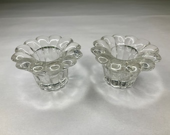 May include: Two clear glass candle holders shaped like flowers with fluted sides.