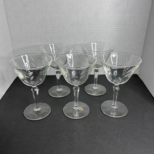 May include: Set of five clear glass stemmed cocktail glasses with a delicate etched floral design.