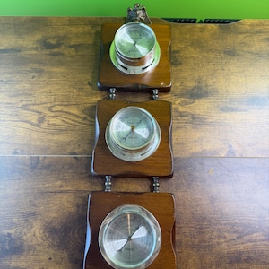 Puede incluir: Un juego de tres tazas de cerámica con un acabado mate moteado. Las tazas son de color crema, gris claro y gris oscuro. Cada taza tiene un diseño simple y minimalista y un asa redondeada.